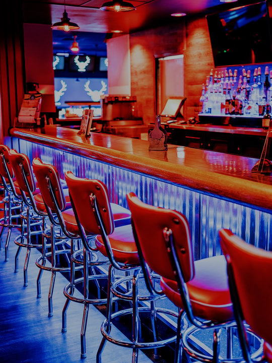 neon lit bar with bar chairs