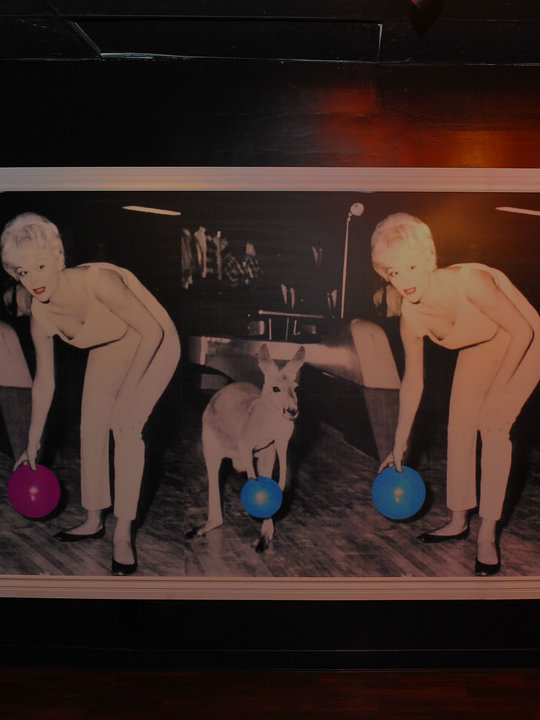 vintage posters on wall of woman and kangaroo holding bowling balls