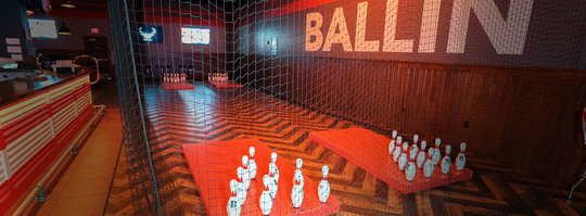 four sets of bowling pins set up on opposite ends of a room