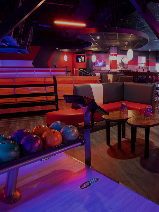 image of a bowling alley with booths and ball racks