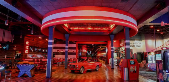 Retro red car with an arcade behind it