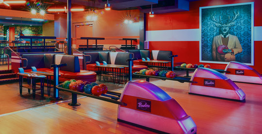 image of bowling lanes, ball racks, and booth seats