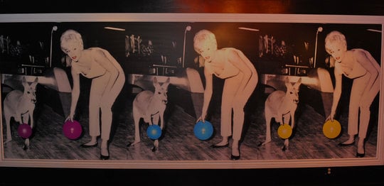 Vintage posters on wall of woman and kangaroo holding bowling balls