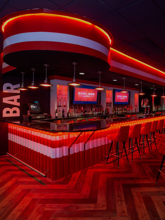 bar area with neon lighting and stools