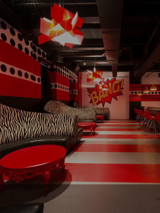 pop art lounge and lanes. Zebra print couches and red chairs and walls.