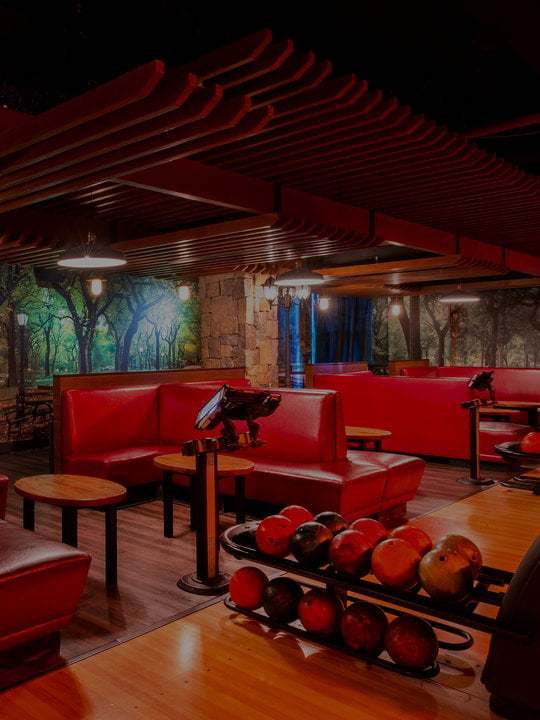Central Park lanes. Red couches with tree mural on walls.