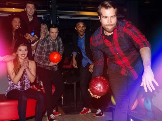 Man bowling in front of group