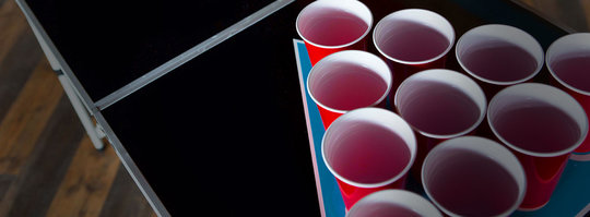 a triangle of red solo cups on a table