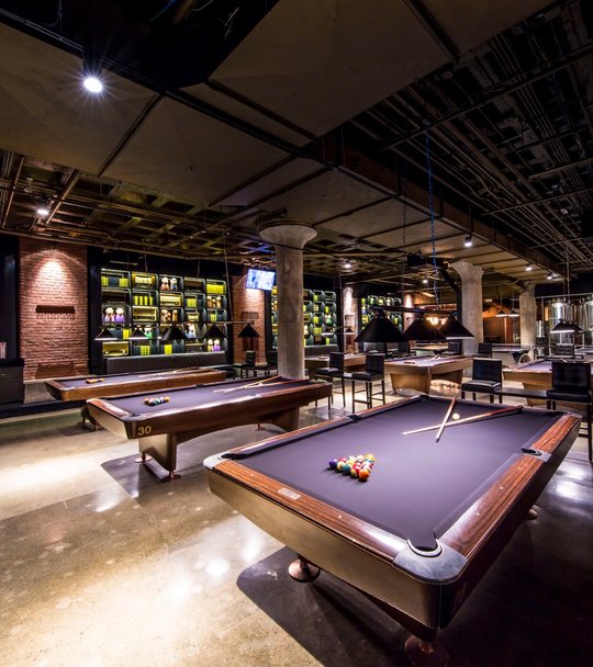 Billiard tables with bar in the background