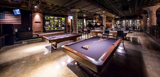 Billiard tables with bar in the background